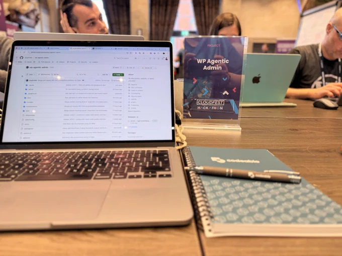 An open laptop and a spiral notebook laying flat on a table