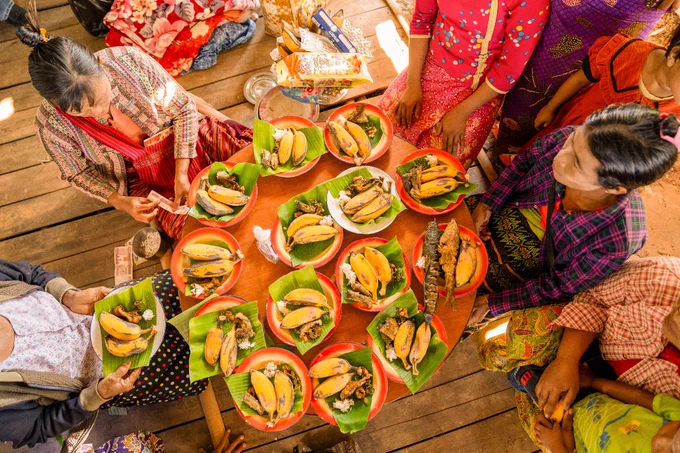 Women from the community prepare and serve food to guests during the housewarming ceremony in Myanmar.
