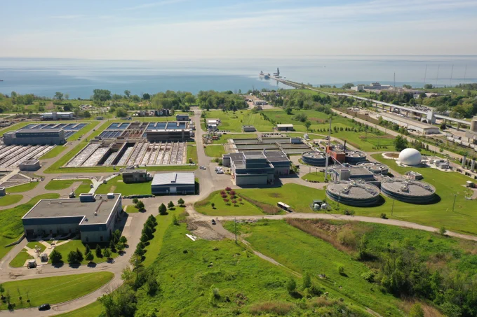 Aerial view of a large wastewater treatment plant near a body of water.