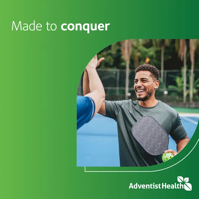A person on a tennis court wearing a green athletic shirt, smiling, and high-fiving another person. They hold a pickleball paddle and ball. The image has a green gradient background with the text "Made to conquer" and the Adventist Health logo.