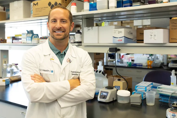 Researcher wearing a lab coat in his lab.