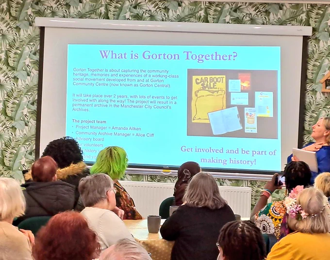 Audience looking at slide show about Gorton community centre 
