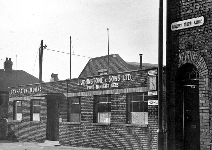 B&W photo of a brick building which is a paint factory 