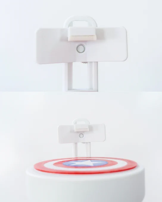 Elevador de plato impreso en 3D visto de perfil, mostrando la base circular y el mecanismo de sujeción frontal con símbolo de Capitán América.
