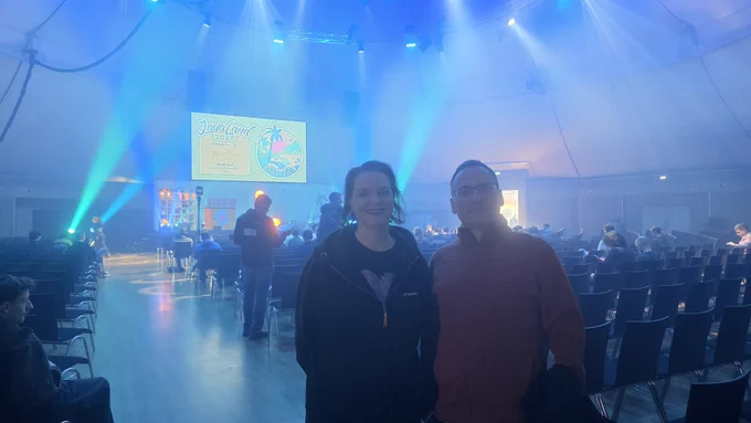 Marit van Dijk and Andres Almiray standing in the Dome. The screen behind them shows a JavaLand banner.