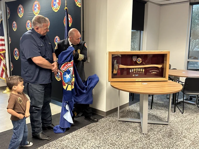 Chief Smith watches on as an axe displayed in a shadow box is unveiled.