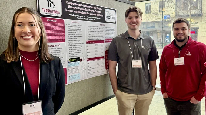 people standing in front of a research poster