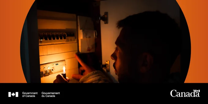 Someone uses their phone as a flashlight to check the breaker
