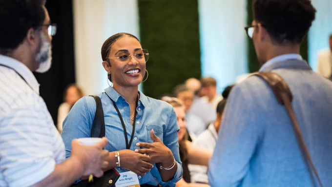 photo of a PIE Network member smiling in conversation at PIE Network Executives' Meeting