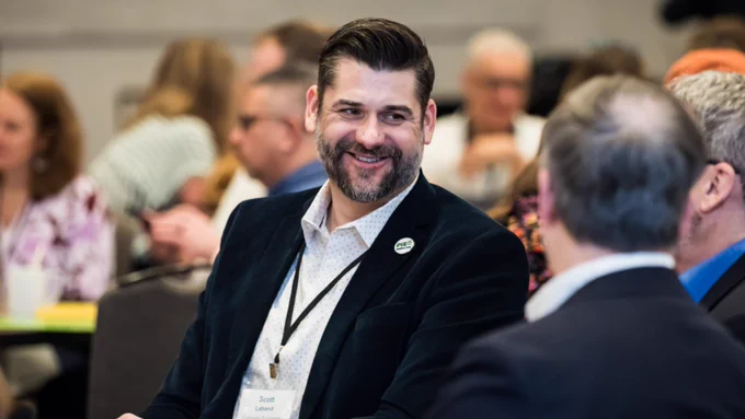 photo of a PIE Network member smiling in conversation at PIE Network Executives' Meeting