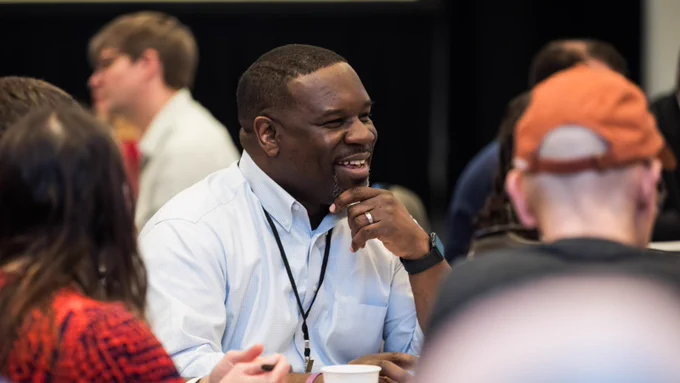 photo of a PIE Network member smiling in conversation at PIE Network Executives' Meeting