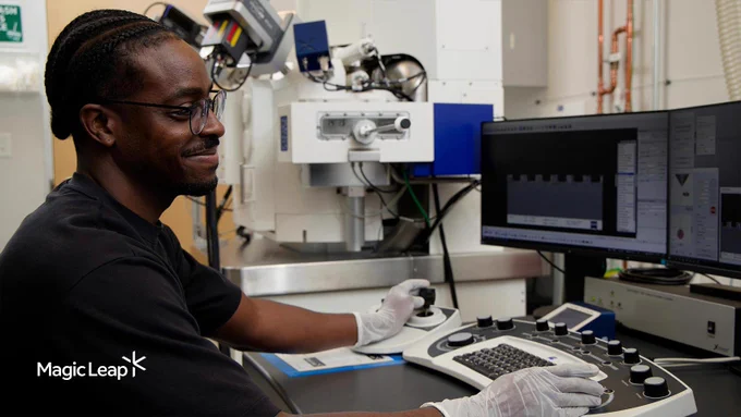  A technician sits in front of monitors in a lab.