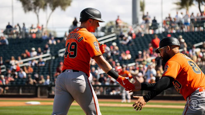Tyler Fitzgerald shakes hand with third base coach Hector Borg while rounding third base after his 2-run HR