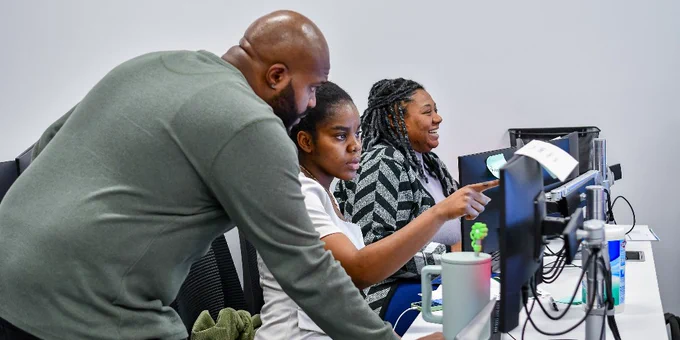 Three ActivateWork learners working at computer stations.