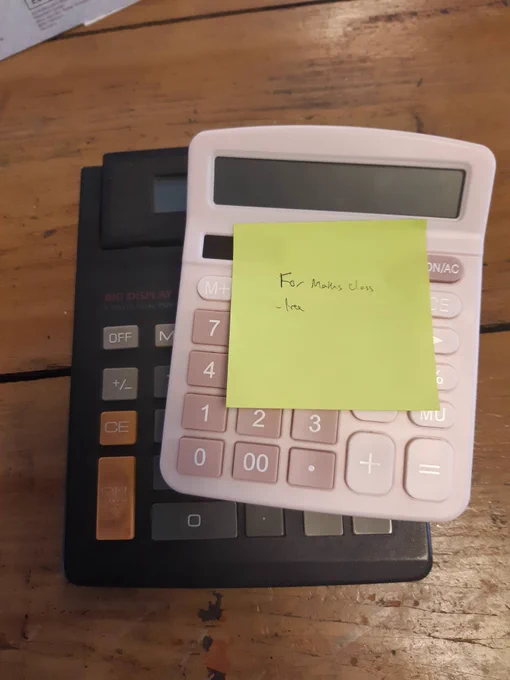 Two calculators on a desk with a note saying 'For maths class, free'