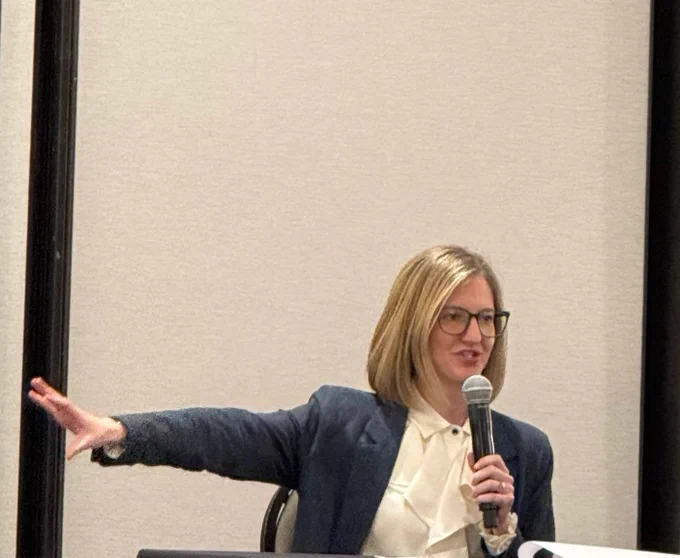 Director Flood speaking into a microphone.