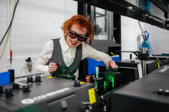 A scientist wearing protective goggles works in a quantum research lab