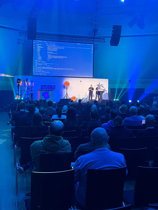 Andres Almiray and Marit van Dijk on stage at JavaLand. The screen behind them shown Maven in IntelliJ IDEA. 