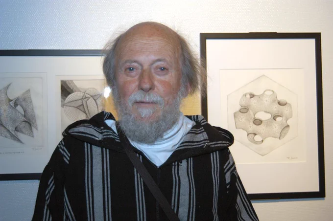 Patrice Jeener, artiste-graveur posant devant deux de ses dessins donnés au Palais de la découverte et installés sur le balcon des mathématiques. À l'occasion de l'inauguration de l'exposition permanente de ces dons, le 27 mai 2009.