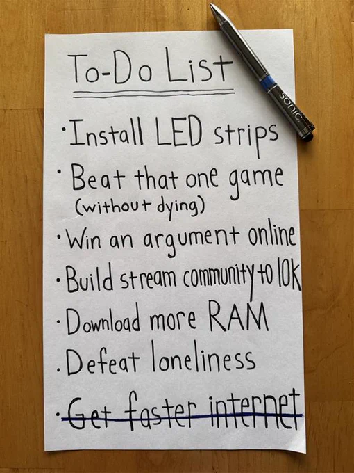Photograph of a handwritten to-do list sitting on a wooden table with a Sonic-branded pen sitting beside it that reads: 
 
"To-Do List 
-Install LED strips  
-Beat that one game (without dying)
-Win an argument online 
-Build stream community to 10K   
-Download more RAM 
-Defeat loneliness  
-Get faster internet"

"Get faster internet" is already crossed off the list. 
