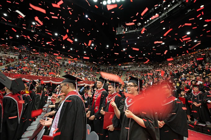 Color indoor photo showing undergraduates celebrate during Spring Commencement  at the first Ceremony on the campus of Washington State University Pullman, Saturday, May 6, 2023.
