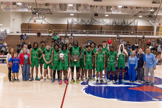 Image of the men’s runners up, Columbia State Community College, on the basketball court holding their awards.