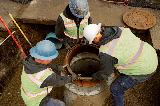 An image of Clean Water Services working on a pipe that is underground. 