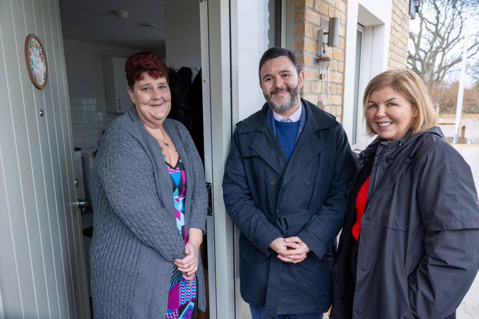 three people at a front door