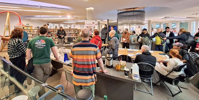 People listening to poetry recitation in library 