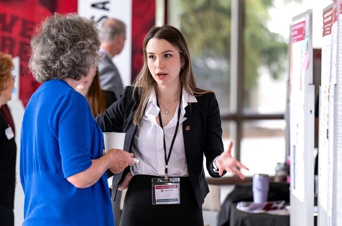 Color indoor photo as a student presents their research to a judge during the Academic Showcase and GPSA Showcase on the WSU Pullman campus Thursday, March 27, 2025 (photo by Shelly Hanks, WSU Photo Services). 