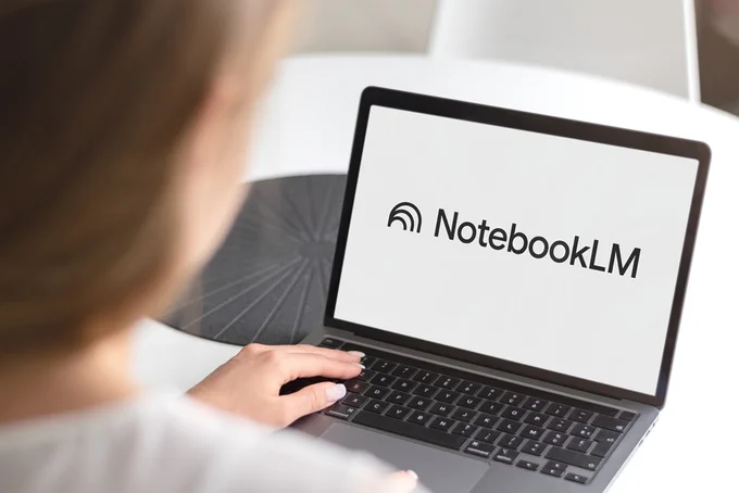 A person is using a laptop displaying the "NotebookLM" logo. The scene suggests a focus on technology or software usage.