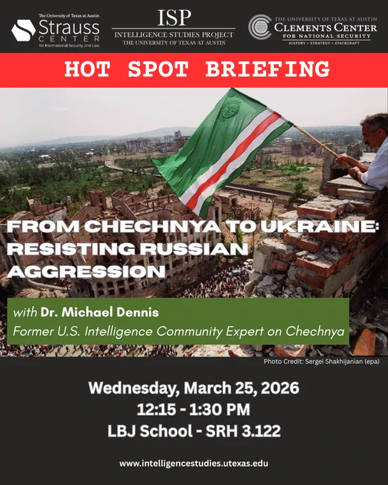 On the righthand side of this image, an older man waves the flag of the Chechen Republic of Ichkeria — colored green, white, and red — over a crowd below as he leans on rubble of a brick wall formerly constituting the rooftop of a building. Beige-colored, destroyed buildings can be seen in the background, and a crowd of what appears to be the city’s inhabitants flows through the street below.  