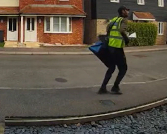 a doorbell camera image of a man wearing a high vis vest and carrying a bag