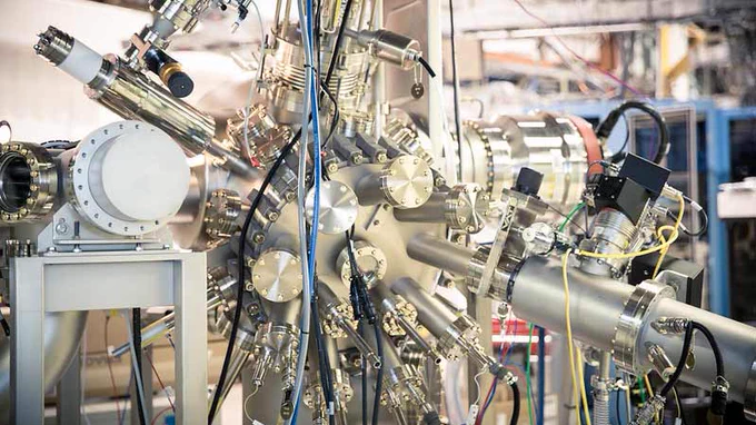 Part of an accelerator beamline. It is a metal machine that has a main sphere with a number of tubes and cylinders coming out of it.