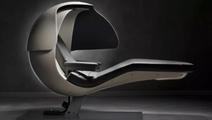 A futuristic energy pod with a sleek, curved design, featuring a reclined chair encased in a smooth, egg-shaped canopy. The pod has a black and white colour scheme with a padded seat and armrests, set against a dark background, highlighting its modern and comfortable appearance for power naps.  