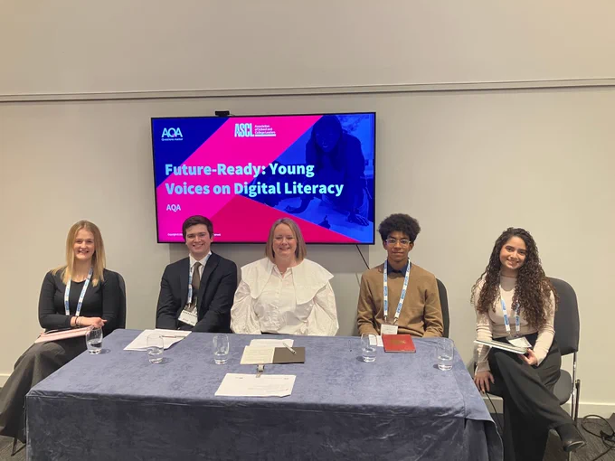 Five people seated behind a desk and in front of a screen that says: Future-Ready: Young Voices on Digital Literacy. 