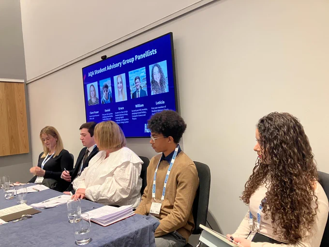 Five people behind a desk taking part in a panel discussion. 