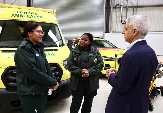 Mayor Sadiq Khan speaks with two London ambulance workers in front of an ambulance