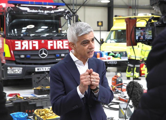 Mayor Sadiq Khan speaking to media in front of a fire engine and ambulance