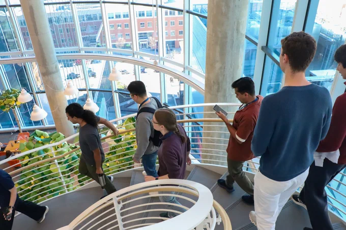 A group of students walking down a spiral staircase.