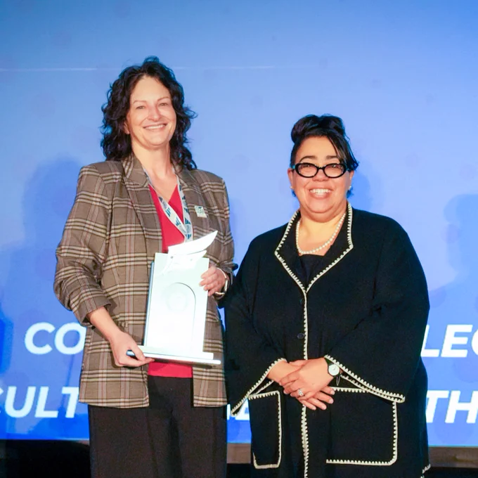 Community College Faculty of the Year recipient Dr Lacey Benns posing with her trophy beside Dr. Jothany Reed.
