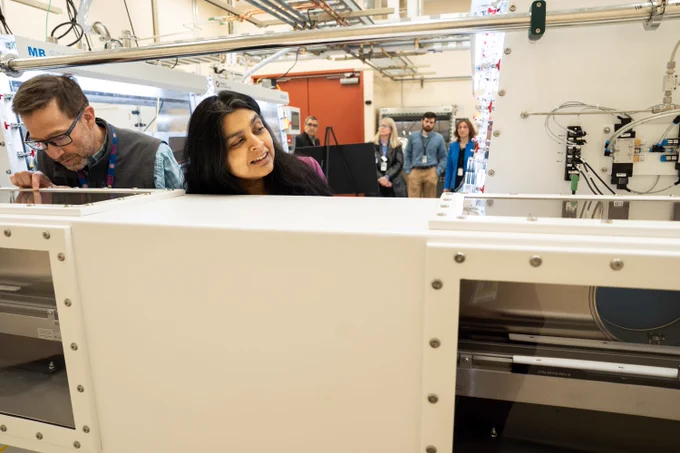Photo of Dr. Bindu Nair, associate director of Basic Energy Sciences as the U.S. Department of Energy Office of Science, looking over the Anaerobic Microbial Phenotyping Platform (AMP2) instruments at the Environmental Molecular Sciences Laboratory (EMSL).