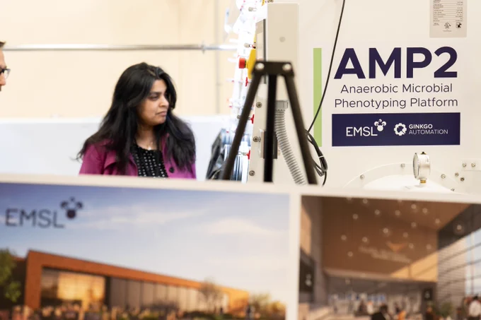 Photo of Dr. Bindu Nair, associate director of Basic Energy Sciences as the U.S. Department of Energy Office of Science, looking over the Anaerobic Microbial Phenotyping Platform (AMP2) instruments at the Environmental Molecular Sciences Laboratory (EMSL).