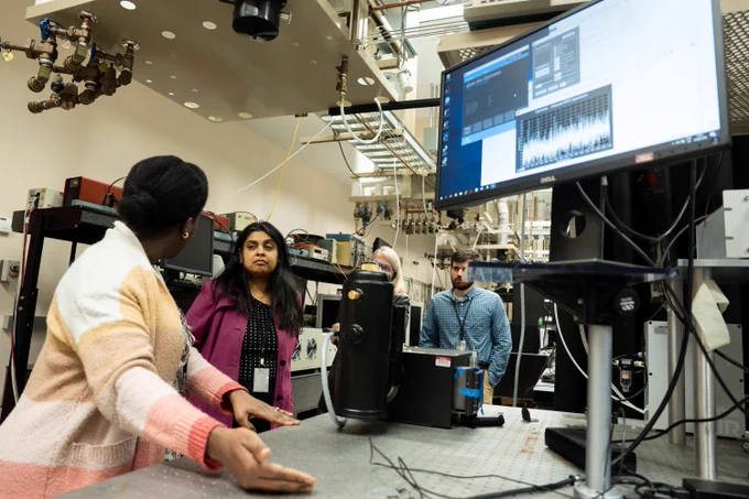 Photo of Dr. Bindu Nair, associate director of Basic Energy Sciences as the U.S. Department of Energy Office of Science, speaking with researchers in a lab at the Environmental Molecular Sciences Laboratory (EMSL).