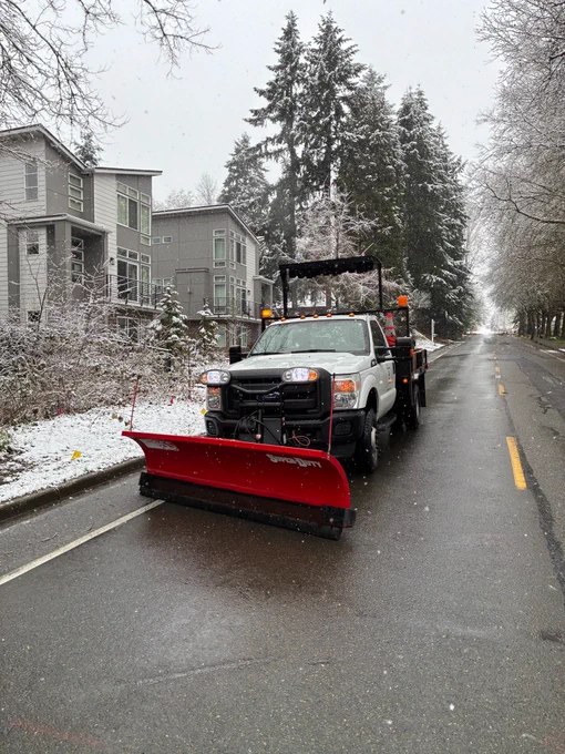 A City of Bothell Public Works truck with a snowplow blade attached at the front, on a roadway.
