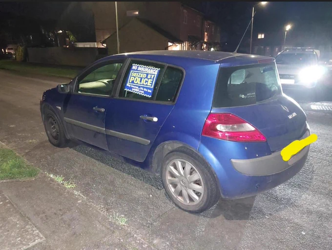 Uninsured and untaxed car with 'seized by police' sticker on window