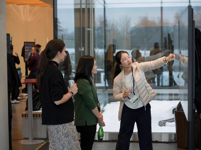 3 people gathered around a poster presentation at Janelia's Research Campus