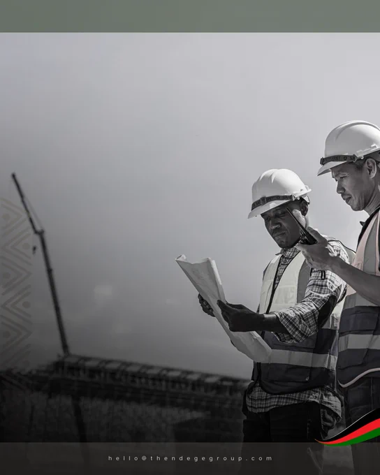 A black and white photograph of two construction workers in white hard hats and high-visibility vests, one Black African and one East Asian, standing side by side on an open construction site reviewing blueprints together. A steel pole and construction activity are visible in the soft background. Overcast sky above. African geometric chevron patterns mark the left border. A dark green tonal bar at the top. A rendition of the Pan-African Flag, with visual influence from the Kenyan flag, in the lower right corner. Two engineers from different continents reading the same plan: the precise image of what ethical, mutually beneficial infrastructure partnership looks like in practice. The Ndege Foundation© | The Ndege Group® | Africa’s Sovereign Development Trust® (ASDT) | hello@thendegegroup.com