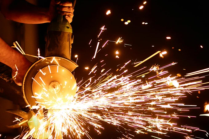 A symbolic picture showing an angle grinder and flashing sparks.
