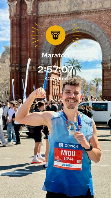 Midudev delante del arco del triunfo, sonriendo y sacando músculo orgulloso de su mejor marca personal en maratón